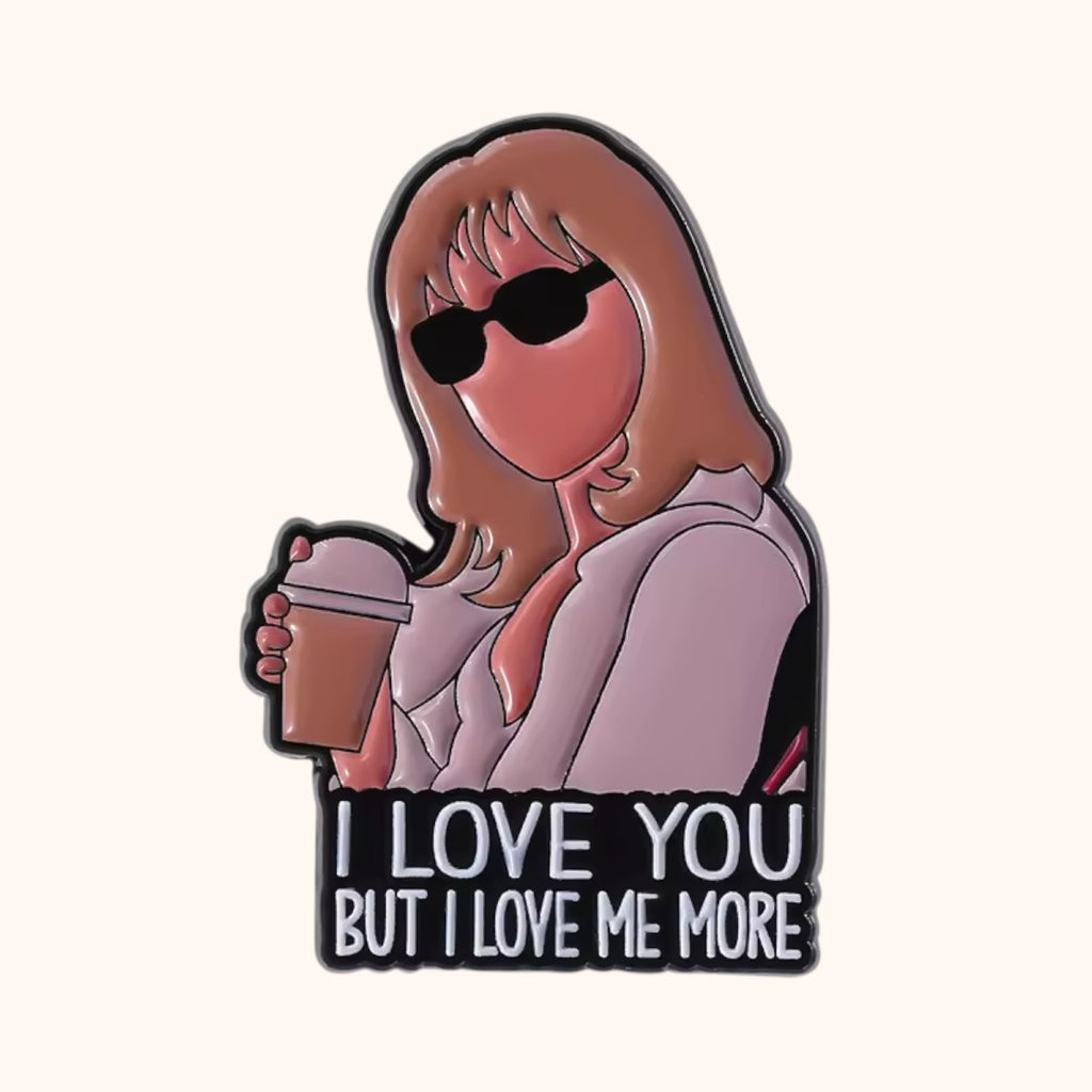 An enamel pin featuring an illustration of SATC-inspired Samantha Jones black sunglasses, and a pink blazer holding a coffee cup, with the text 'I LOVE YOU BUT I LOVE ME MORE' on a black background.