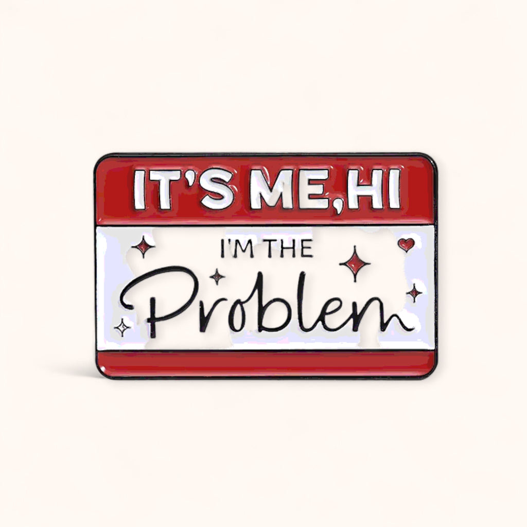 Enamel pin with text 'IT'S ME, HI I'M THE Problem' 