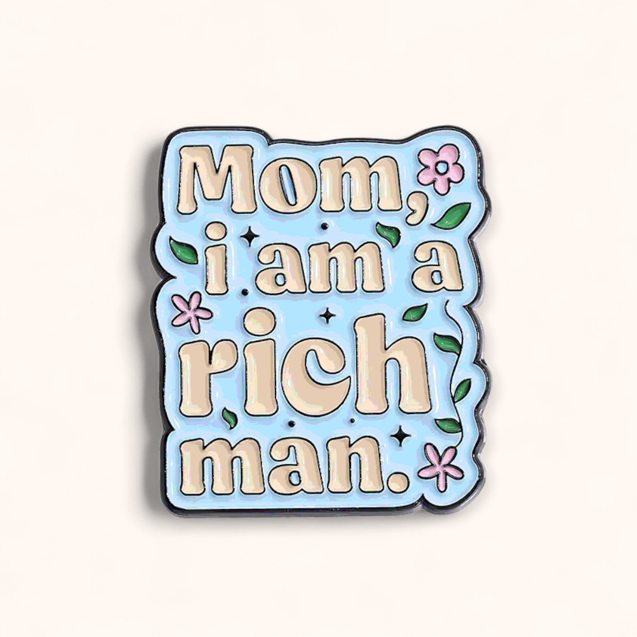 Enamel pin with text 'Mom, i am a rich man.' on a light blue background